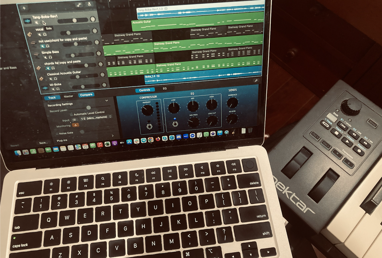 A laptop running Logic Pro beside a MIDI keyboard
